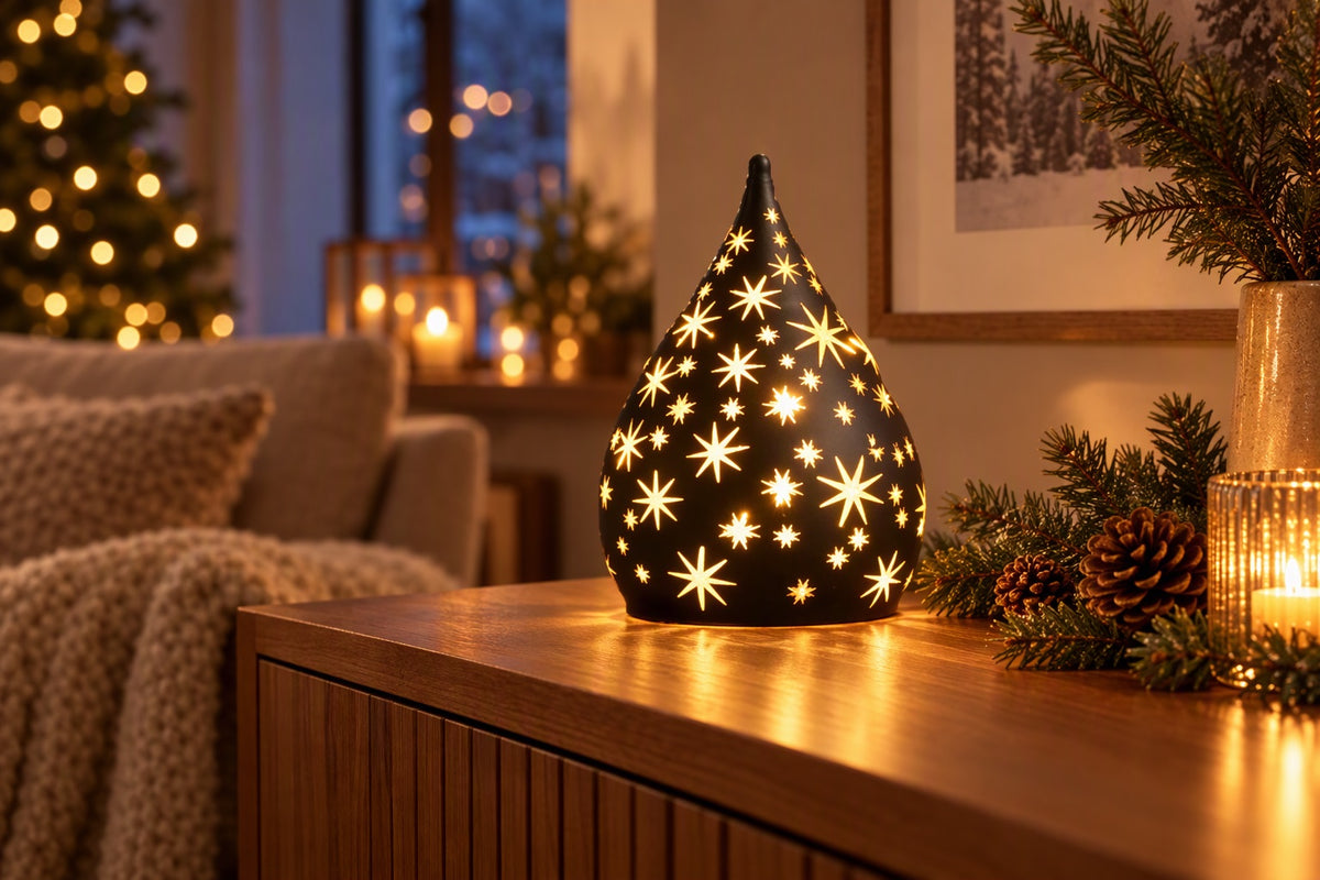 Goutte lumineuse LED noire percée d'étoiles allumée sur un buffet