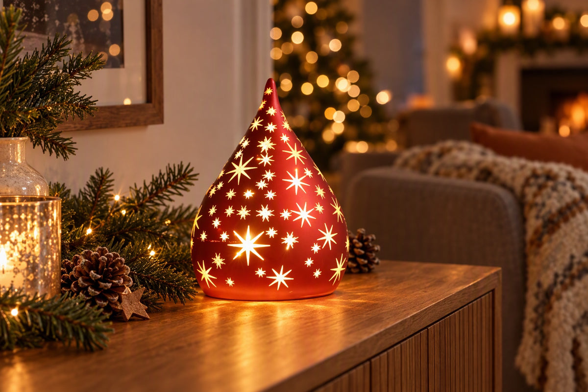 Goutte lumineuse LED rouge percée d'étoiles allumée sur un buffet