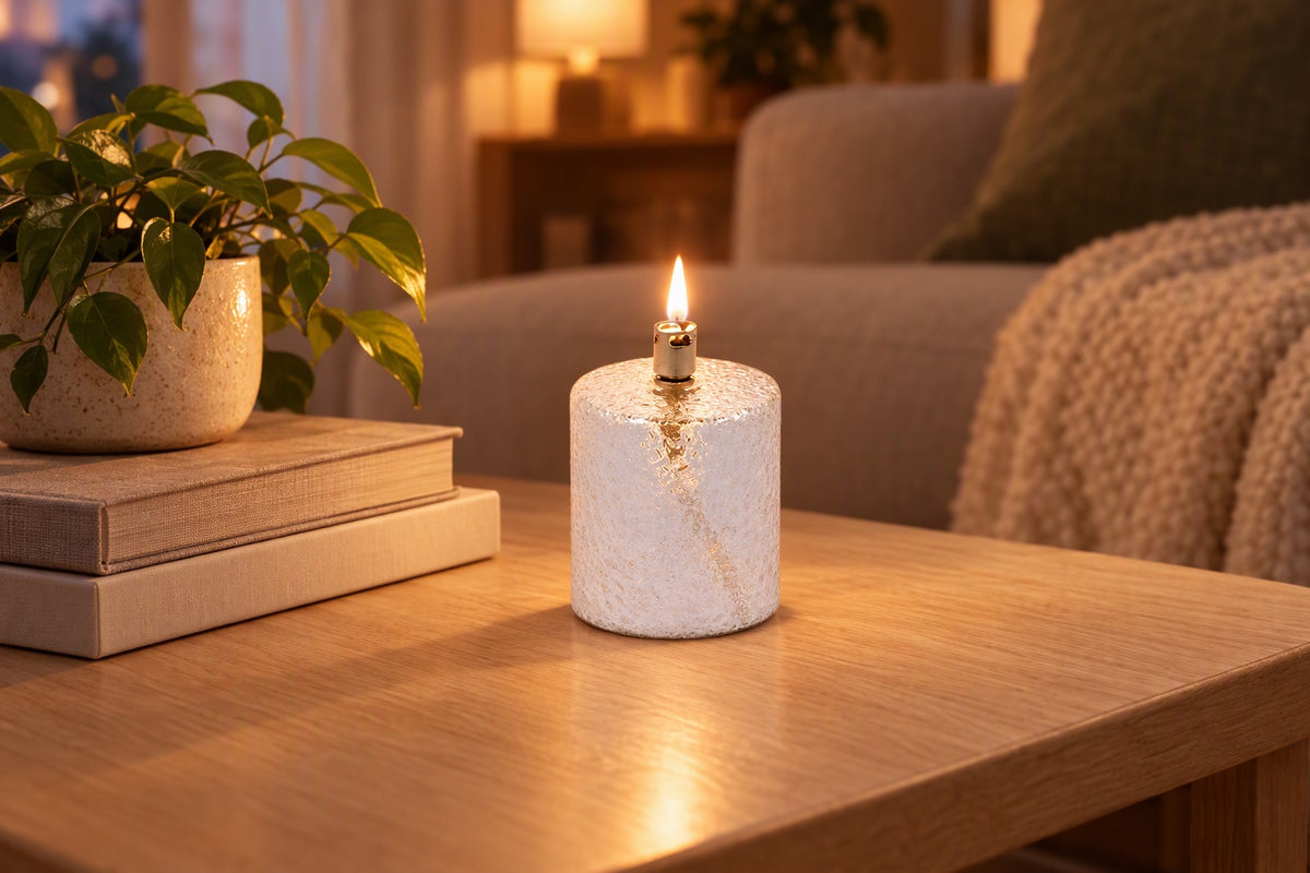 Lampe à huile cylindrique en verre martelé allumée sur une table basse