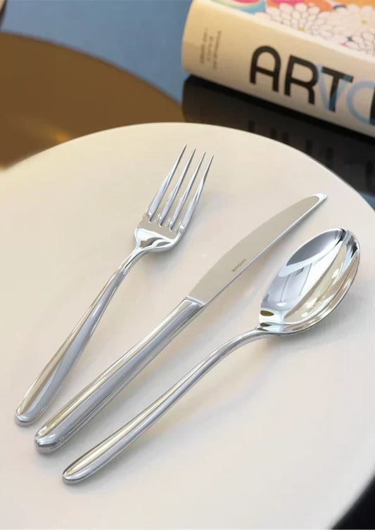 Fourchette, couteau et cuillère disposés sur une assiette pour bien dresser le couvert