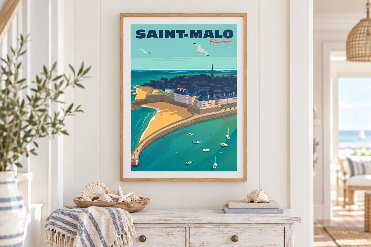 Affiche Saint-Malo Intra-Muros encadrée au-dessus d'une console blanche dans une entrée bord de mer
