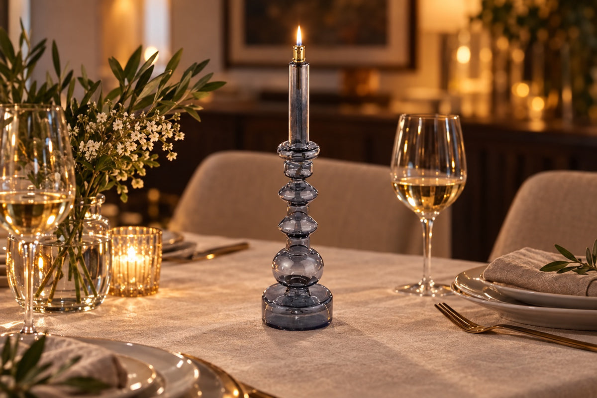 Bougeoir lampe à huile en verre gris fumé allumé sur une table dressée