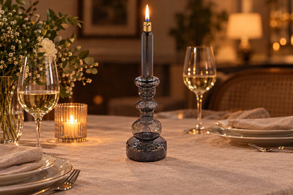 Bougeoir lampe à huile en verre gris fumé allumé sur une table dressée