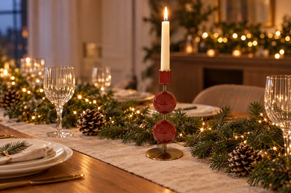 Bougeoir rouge avec bougie allumée sur une table de Noël avec branches de sapin