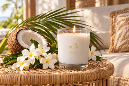 Bougie Fleur de tiaré allumée sur une table en rotin avec fleurs blanches et noix de coco