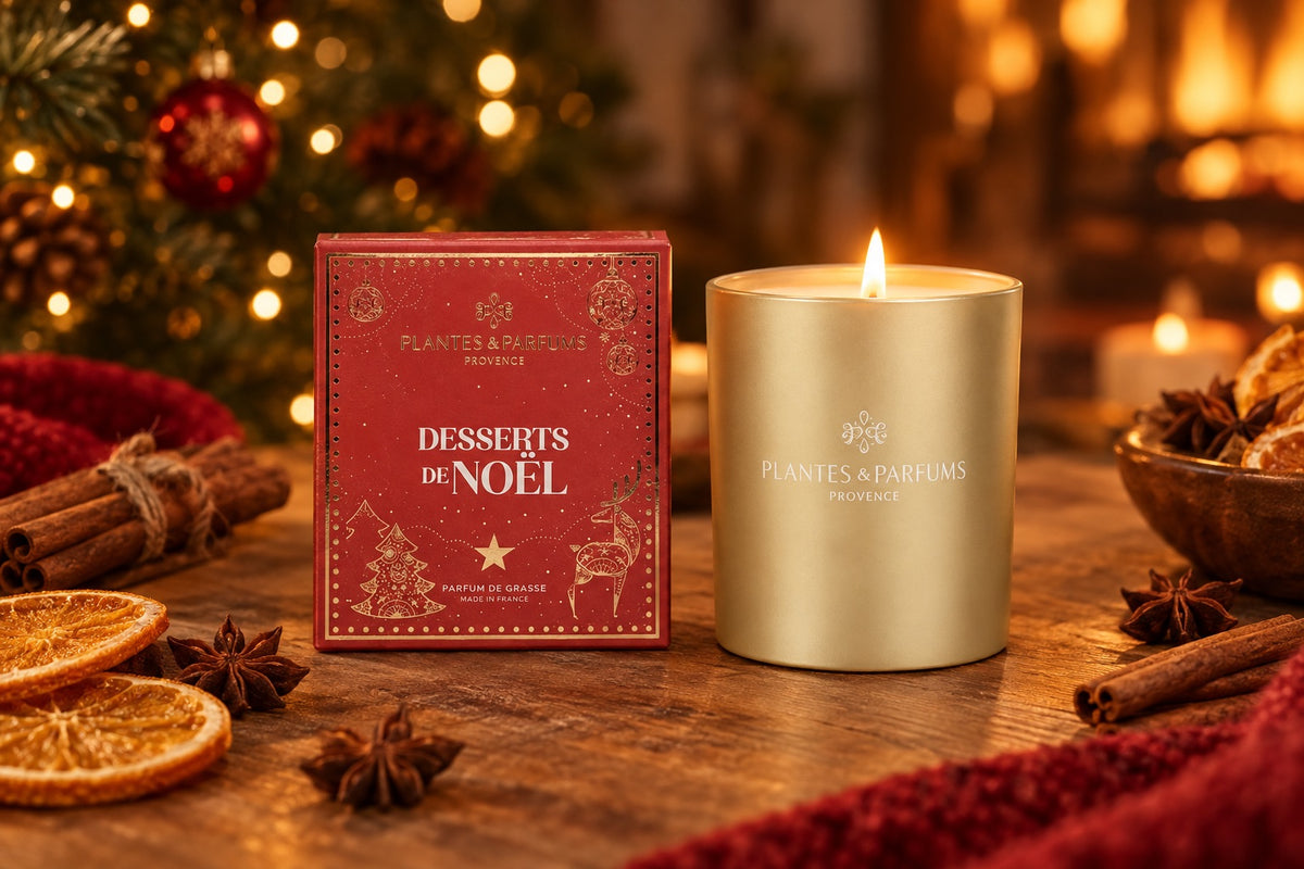 Bougie parfumée Dessert de Noël allumée près de son coffret rouge sur une table de fête