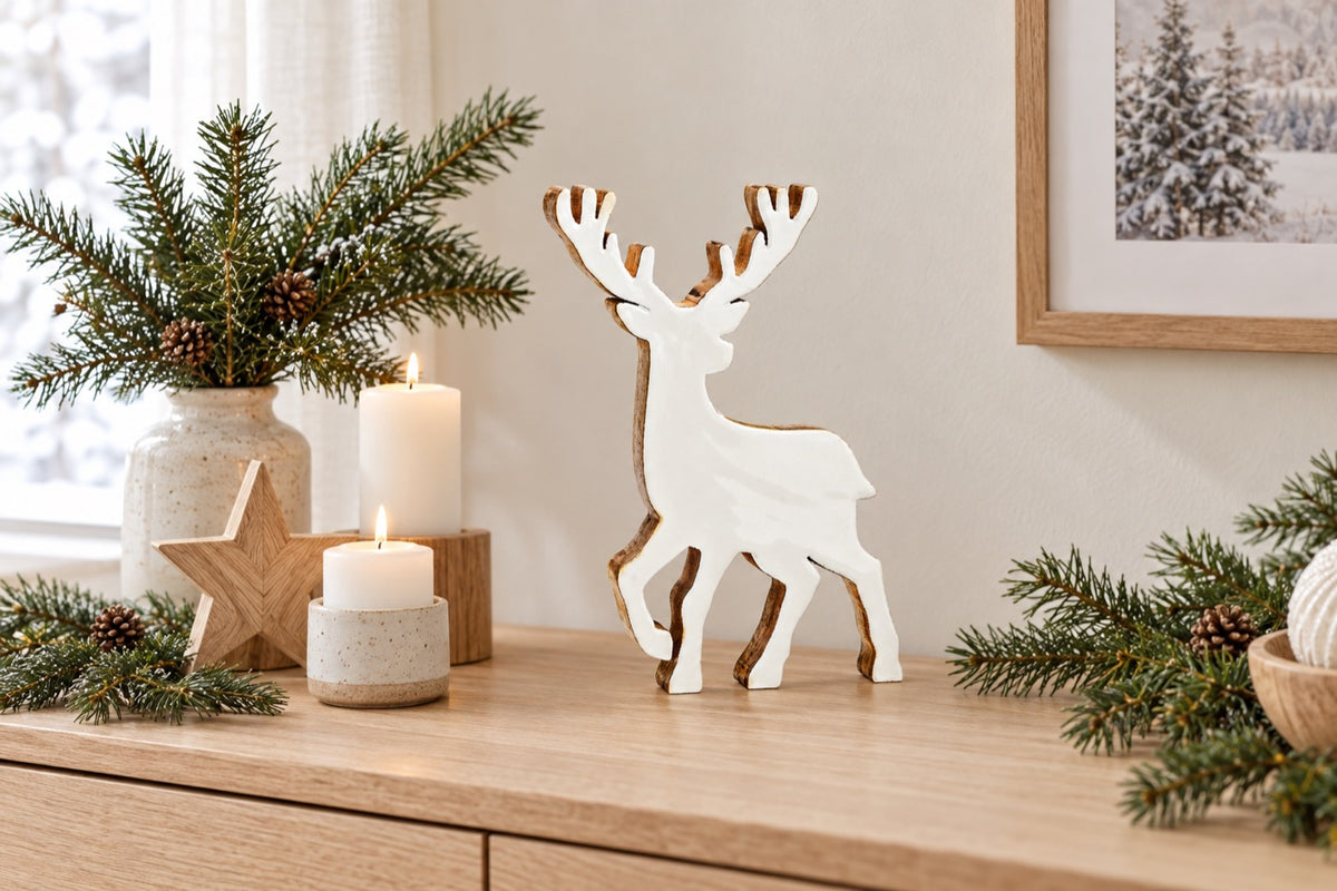 Cerf de Noël en bois naturel et blanc sur une console avec branches de sapin et étoile en bois