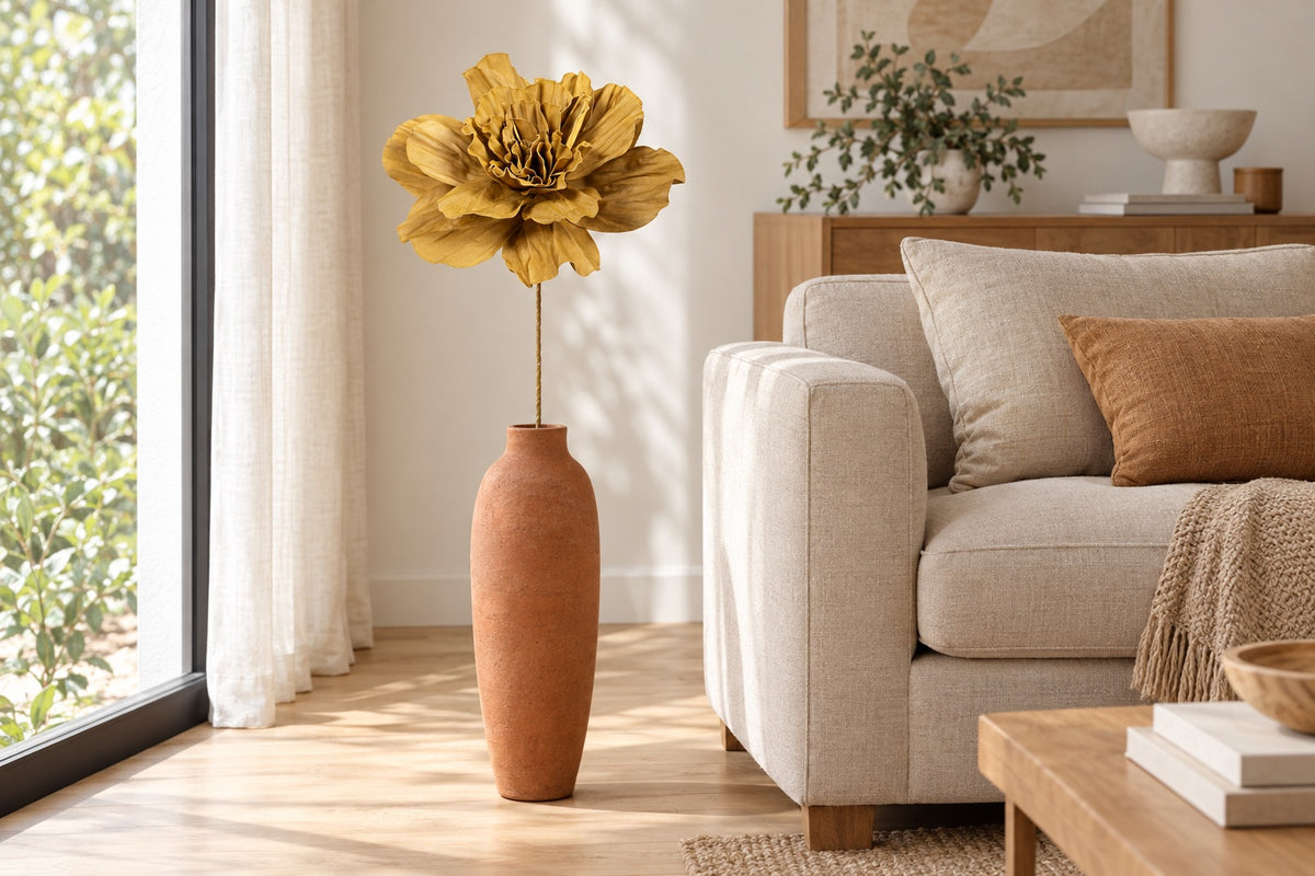 Fleur géante artificielle moutarde dans un grand vase dans un salon