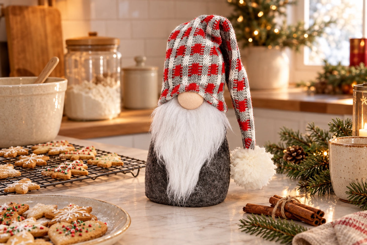 Boîte à biscuits gnome de Noël gris, blanc et rouge sur un plan de travail avec des sablés de Noël