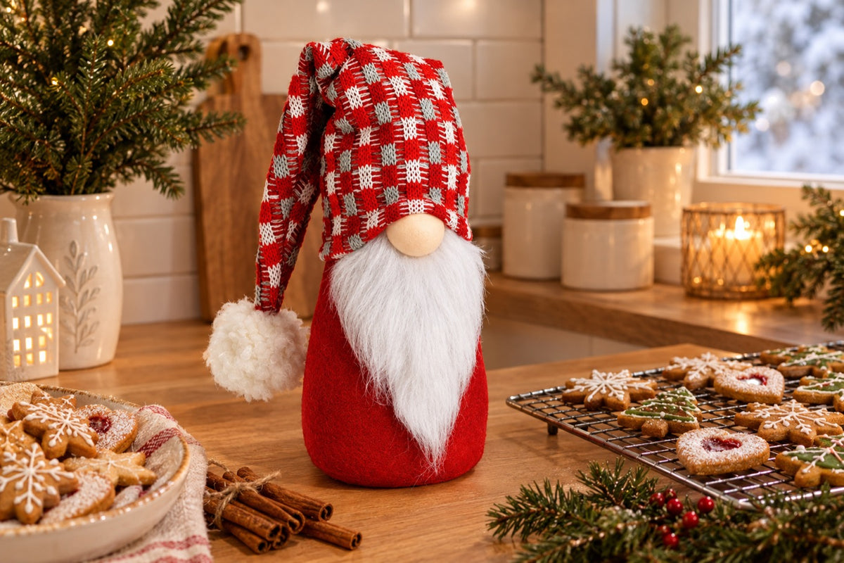 Boîte à biscuits gnome de Noël rouge et blanc sur un plan de travail avec des sablés de Noël