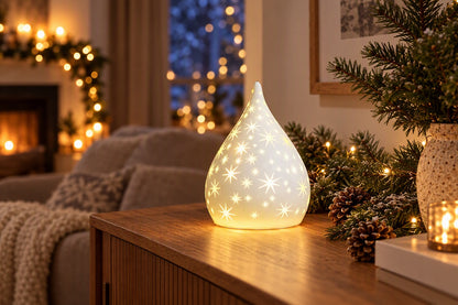 Goutte lumineuse LED blanche percée d'étoiles allumée sur un buffet