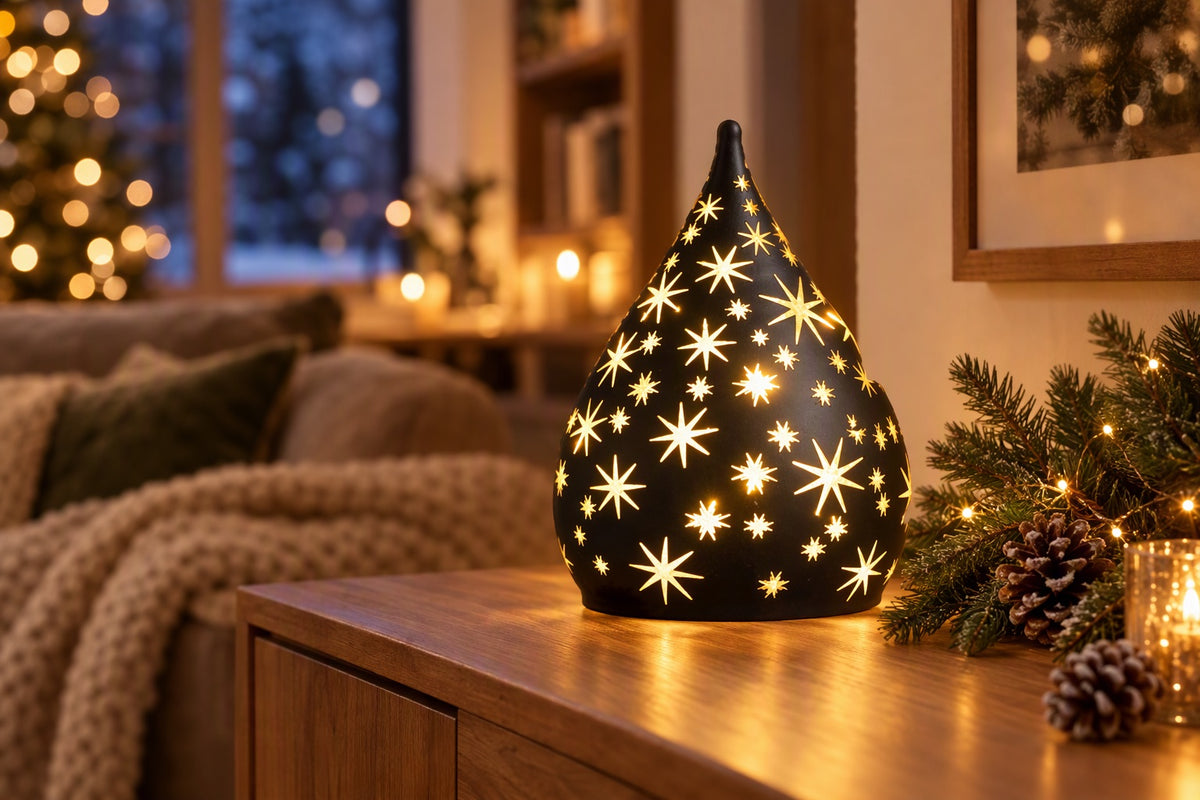 Goutte lumineuse LED noire percée d'étoiles allumée sur un buffet
