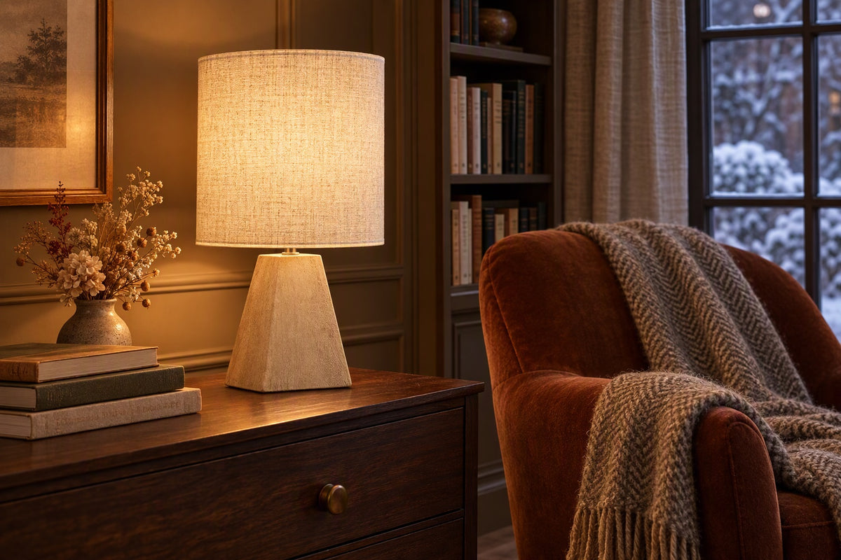 Lampe lin et bois allumée sur une commode dans un coin lecture un soir d'hiver