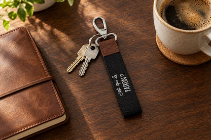Porte-clés C'est qui le patron gris et marron avec un trousseau de clés sur une table en bois