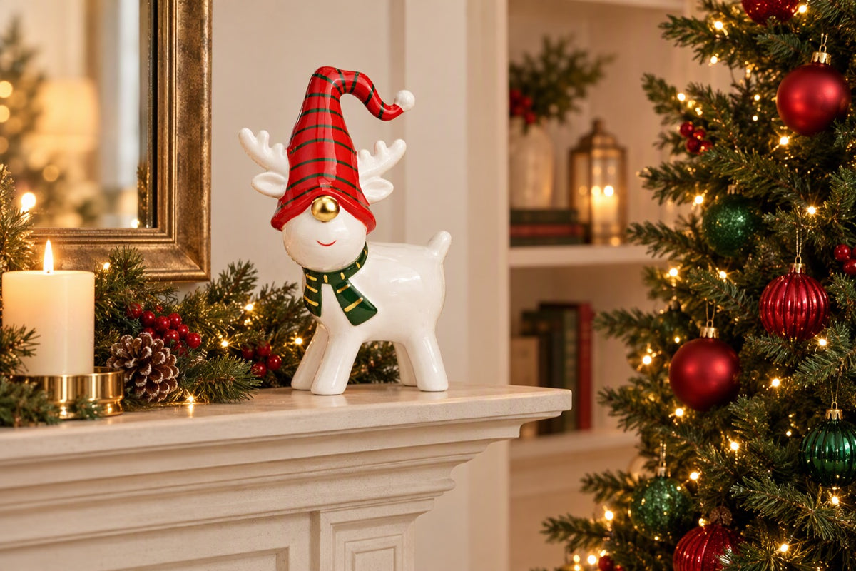 Renne de Noël en céramique GM blanc, rouge et vert posé dans une décoration de fêtes