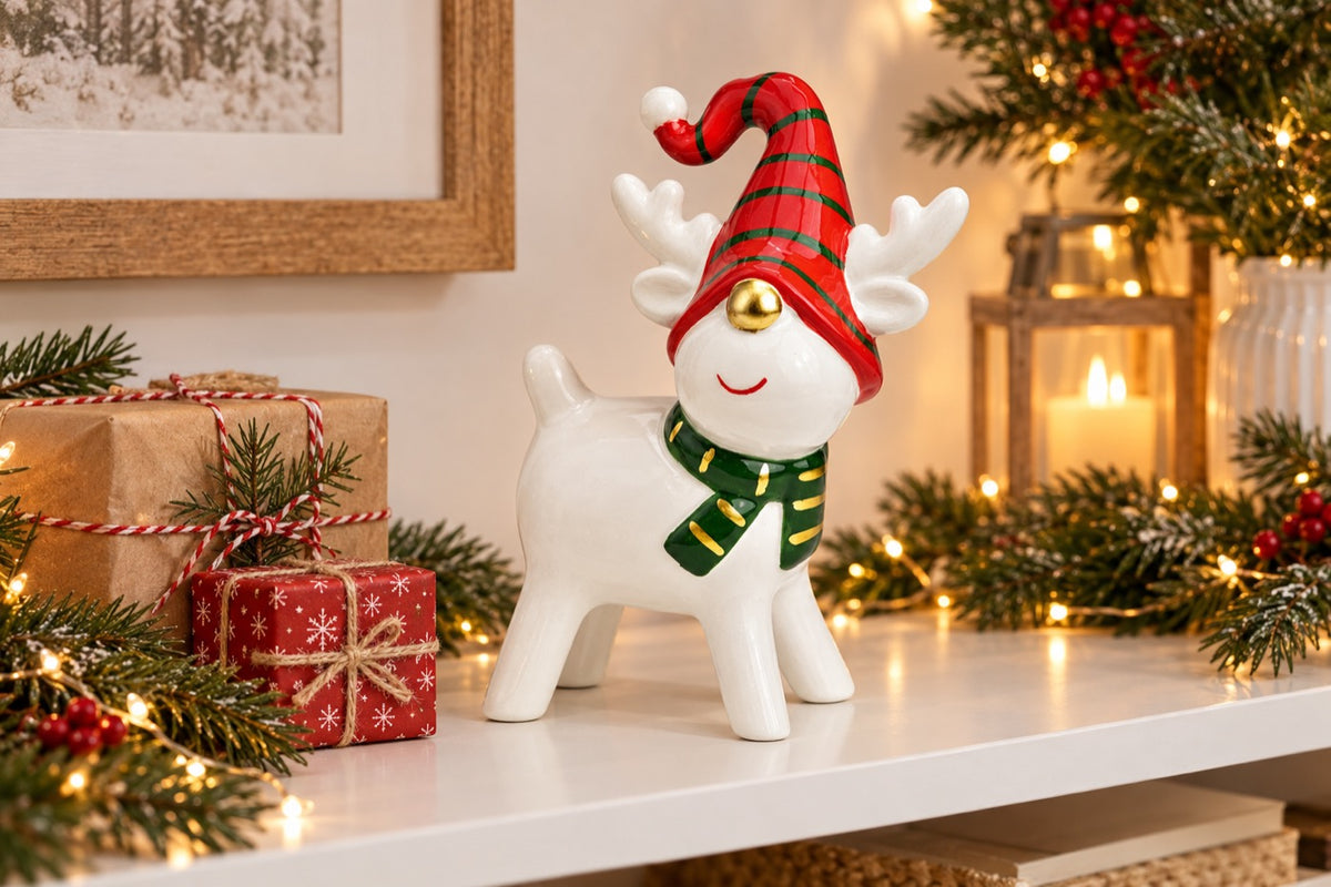 Renne de Noël en céramique MM blanc, rouge et vert posé dans une décoration de fêtes
