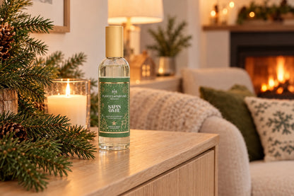 Spray d'ambiance Sapin givré posé sur une console près de branches de sapin