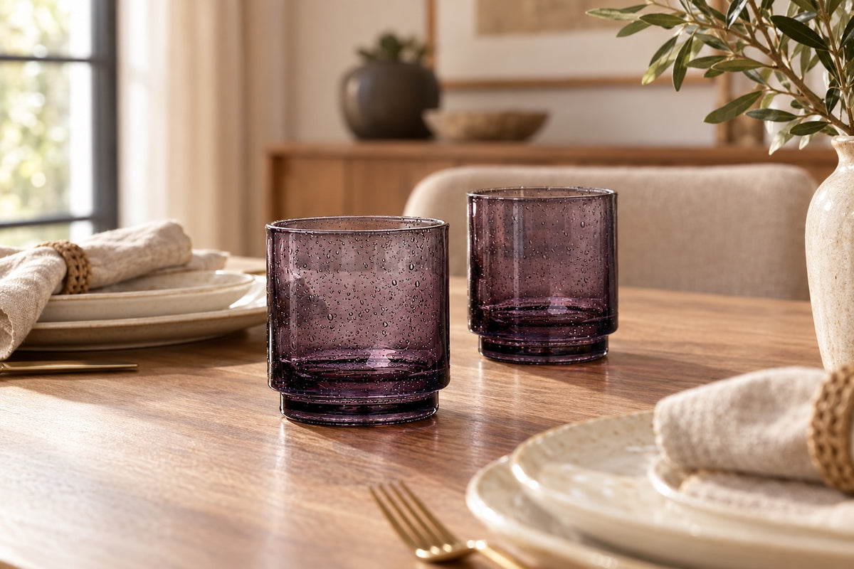 Verres empilables noir fumé sur une table dressée avec vaisselle claire