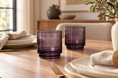 Verres empilables noir fumé sur une table dressée avec vaisselle claire
